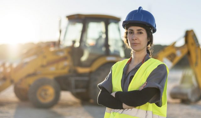 Worker woman looking at camera after working in sunset image woman in construction